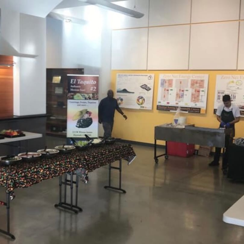 El Taquito Restaurant Dos catering setup with food on tables and two men in the background.