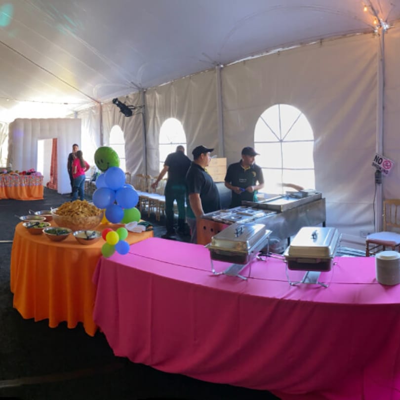 El Taquito Restaurant Dos catering setup with buffet tables, chafing dishes, and staff under a white tent.